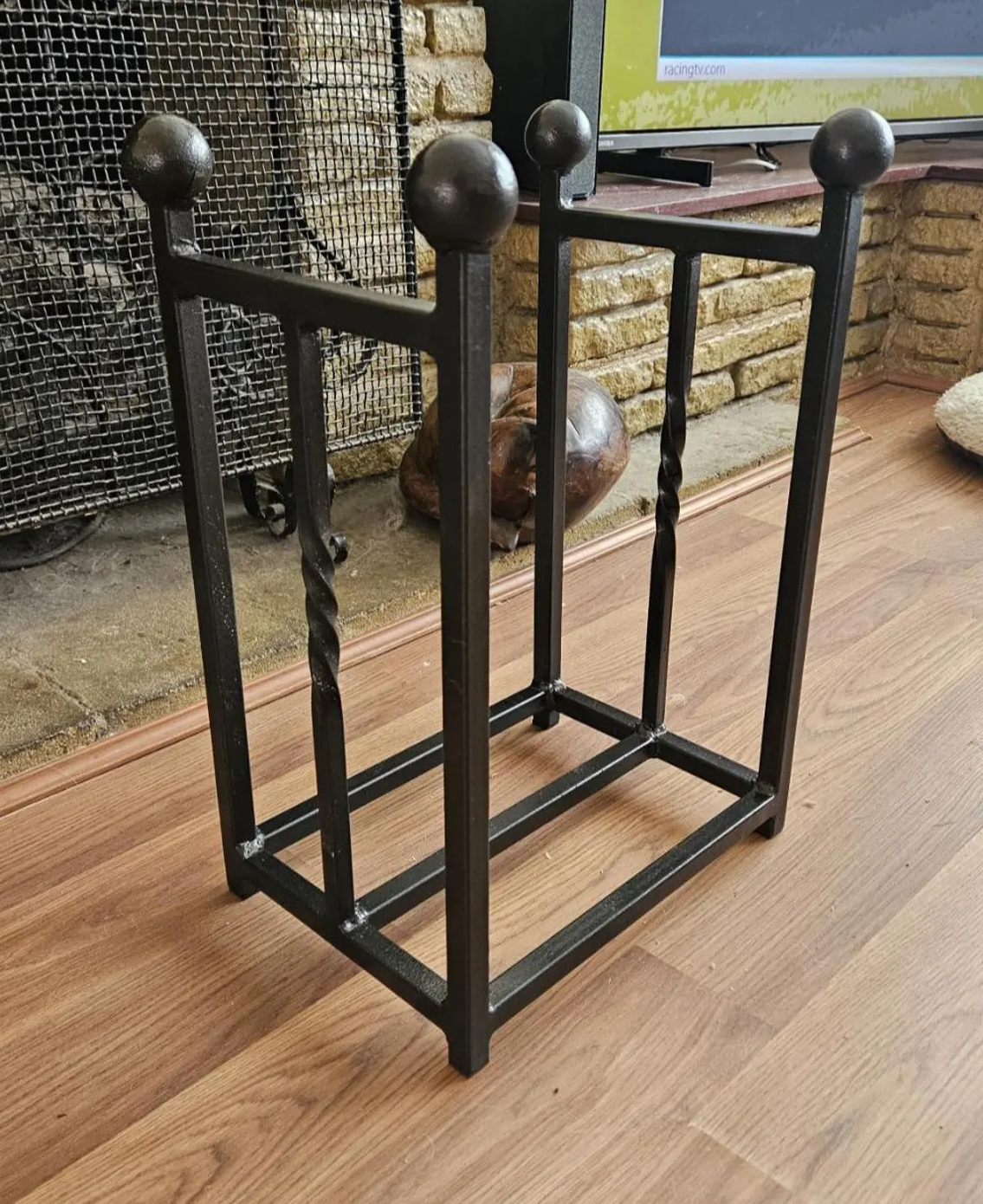 Traditional steel log store with twisted bar detailing. Handmade and crafted in the UK