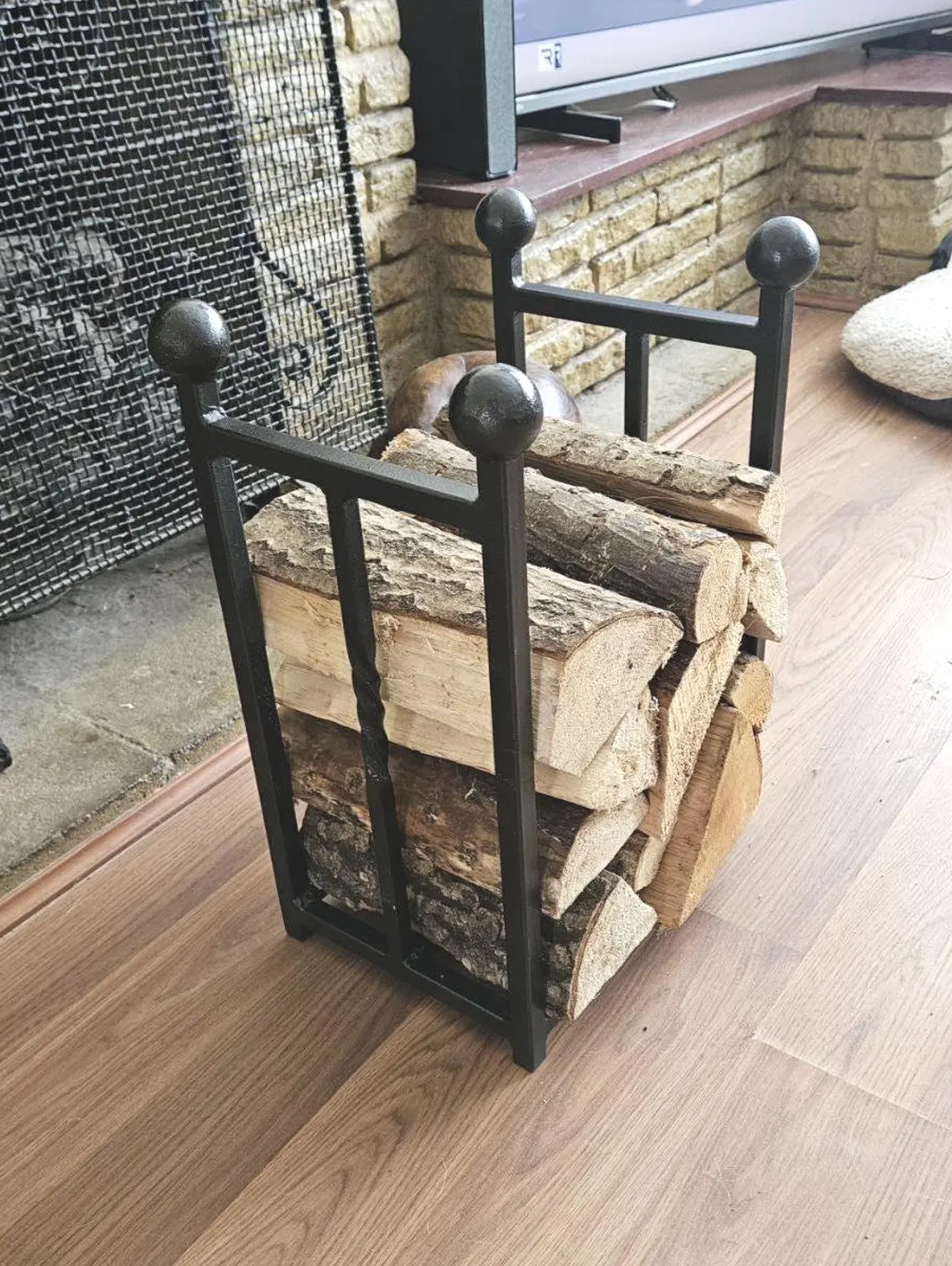 Traditional steel log store with twisted bar detailing. Handmade and crafted in the UK